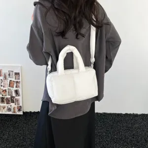 Minimalist white padded tote bag with quilted texture and an adjustable shoulder strap