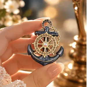 Vintage nautical anchor brooch with gold ship wheel design and inset rhinestones