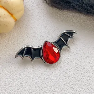 Halloween devil bat brooch featuring a faceted red crystal and black enamel wings