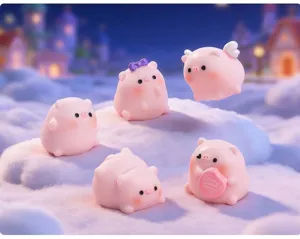 Group of cute pink miniature pig figurines in a dreamy snowy winter landscape setting