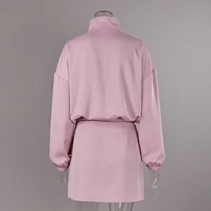 Rückansicht eines rosa Freizeit-Zweiteilers mit Stehkragenjacke und kurzem Rock