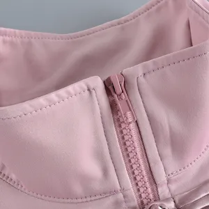 Nahaufnahme des glatten rosa Reißverschlussdetails an einem eleganten Oberteil.