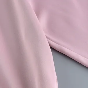 Détail en gros plan de la texture du tissu rose et des coutures d'un ensemble mode chinois.
