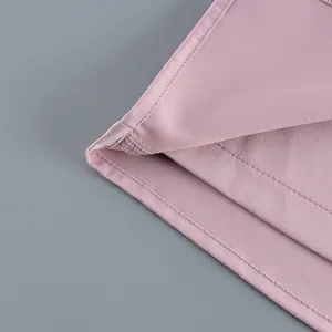 Gros plan de l'ourlet en tissu rose lisse avec coutures nettes pour l'ensemble.
