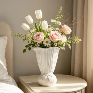Detailansicht einer weißen gerippten Keramikvase mit eleganter Schleife auf einem Nachttisch