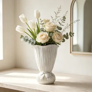 Elegante weiße Keramikvase mit gewelltem Rand und Schleife in einer Wohnumgebung