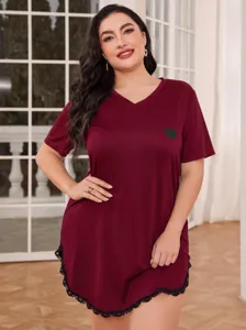 Detail of a plus size burgundy V-neck nightdress with black lace hem and heart motif.