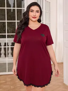 Detailed view of a plus-size burgundy nightgown featuring a V-neck and delicate lace hem