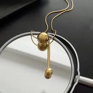 Collier minimaliste en acier titane doré avec pendentif géométrique à billes et barres