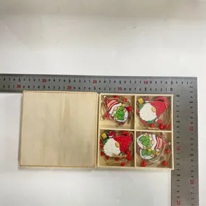 Vista detallada de gnomos navideños de madera en caja con regla para las dimensiones