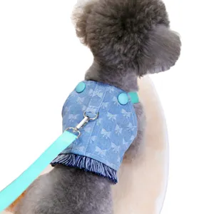 Light blue denim dog harness with bow pattern and fringe detail on white background