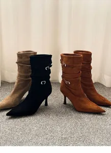 Close-up of stylish pointed-toe stiletto ankle boots with buckle and slouchy design
