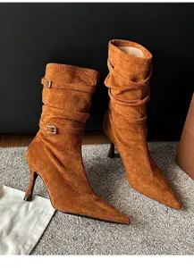 Detailed view of brown suede pointed-toe boots with buckle straps and slouchy texture