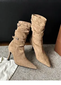 Detail view of brown suede slouchy ankle boots with buckles and stiletto heels