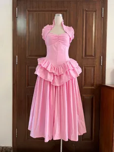 Elegant pink halter neck dress with boning and tiered ruffled skirt on mannequin.