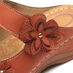 Detail shot of the laser-cut leather flower decoration on vintage brown sandals