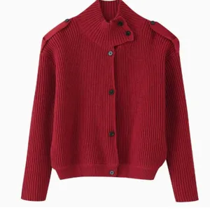 Detalle de un cárdigan de punto rojo con cuello alto y charreteras con botones de moda