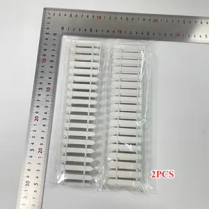 Dettaglio di due mini staccionate in legno bianco con righello per misurazione