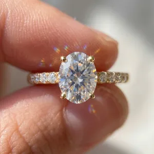 Detailed macro view of a sparkling oval-cut moissanite engagement ring in gold finish