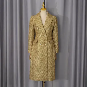 Elegant gold tweed double-breasted coat with blazer collar on mannequin.