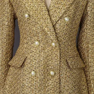 Detailed close-up of golden tweed blazer with elegant pearl button details and texture.