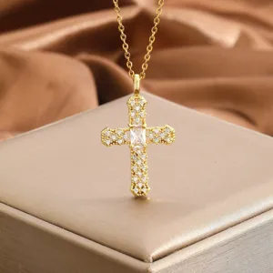 Gros plan détaillé d'un pendentif en forme de croix dorée avec pierres de zircon