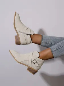 Detailed view of beige pointed-toe ankle boots with side zipper and block heel