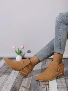Detail shot of stylish tan pointed toe block heel ankle boots with elegant buckle detail