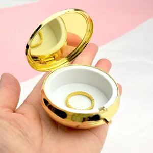 Dettaglio macro di portapillole portatile in metallo dorato da 6 cm con specchio interno