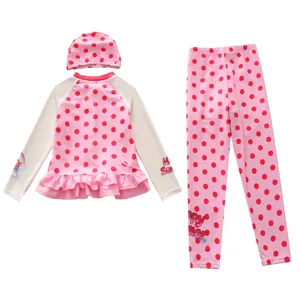 Detailed view of a pink polka dot three-piece long-sleeved swimsuit set for girls