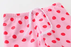 Close-up detail of children's swimwear waist with polka dots and white drawstring
