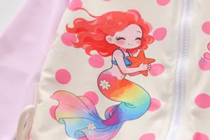 Macro detail showing the colorful mermaid print on a girls long-sleeve zip-up swimsuit