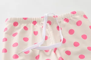 Close-up of girls' pink polka dot swimwear waistband with white adjustable drawstring