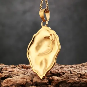 Gold plated stainless steel stylized lion head pendant necklace on natural bark background
