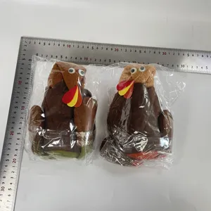 Detail shot of Thanksgiving turkey plush dolls next to a ruler for size reference.