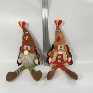 Pair of handcrafted plush Thanksgiving turkey gnomes sitting with a height reference ruler
