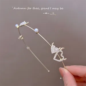 Gros plan d'un serre-tête en métal cœur diable strass scintillant avec perles, accessoire élégant.