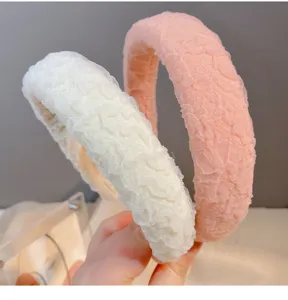 Detail shot of wide sponge hairbands in off-white and pink, crinkled fabric texture.