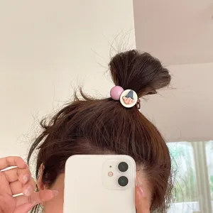Detail shot of quirky cartoon face hair tie, high elasticity rubber band, fashion hair accessory.