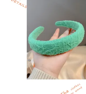 Close-up detail of the wide green textured sponge headband, showing soft fabric texture.
