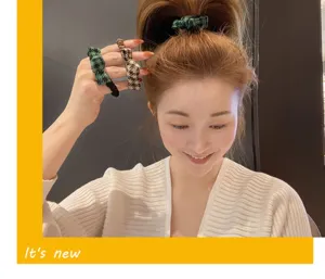 Vue de détail d'élastiques à cheveux élégants à nœud avec motif pied-de-poule pour femmes.