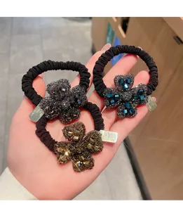 Exquisite rhinestone hair tie detail showcasing sparkling crystal floral hair band and elastic design.