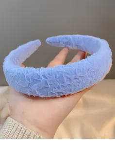 Detailed view of wide blue textured headband, soft sponge padded hair hoop design.