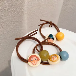Close-up of quirky face hair tie detail, handmade ceramic bead elastic rubber band accessory.