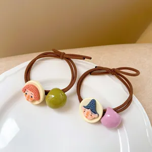 Detail shot of quirky hair tie with cute clay face and colorful bead decoration, chic design.