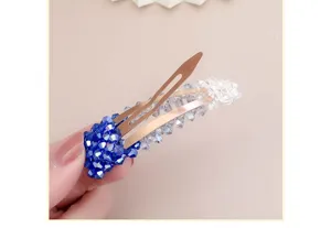 Nahaufnahme Detailansicht der funkelnden blauen Farbverlauf Strass Haarklammer mit Perlen.