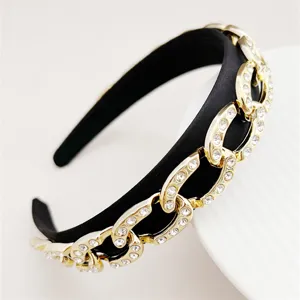 Nahaufnahme Detail des schwarzen Haarreifs mit goldenen Kettengliedern und glitzernden Kristallen.