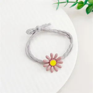 Détail d'élastique à cheveux gris avec fleur de marguerite rose, bel accessoire.