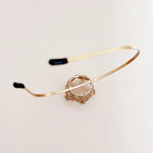 Close-up of the exquisite golden metal headband with hollow crown detail and sparkly white crystals.