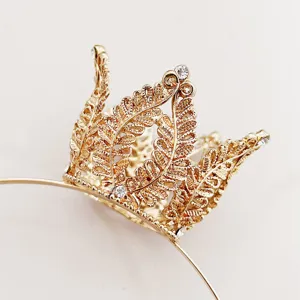 Detailed close-up of a gold crown headband with sparkling rhinestones and delicate leaf pattern.